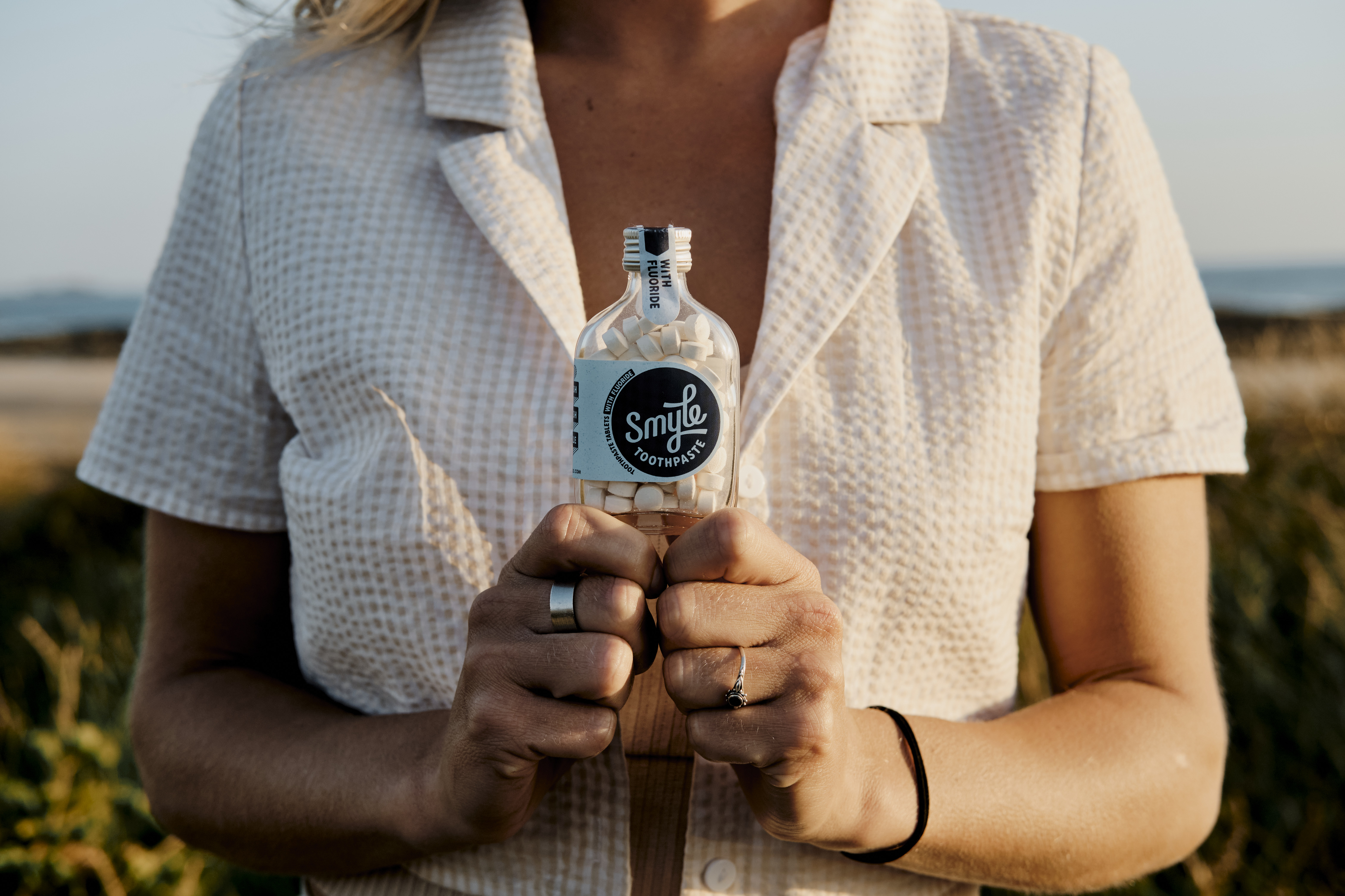 Eine Frau hält eine Flasche mit Smyle-Zahnpastatabs
