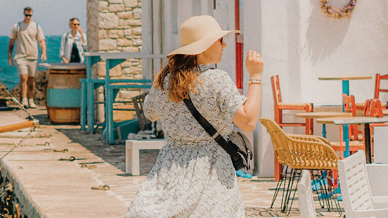 Uma mulher caminhando em uma cidade grega