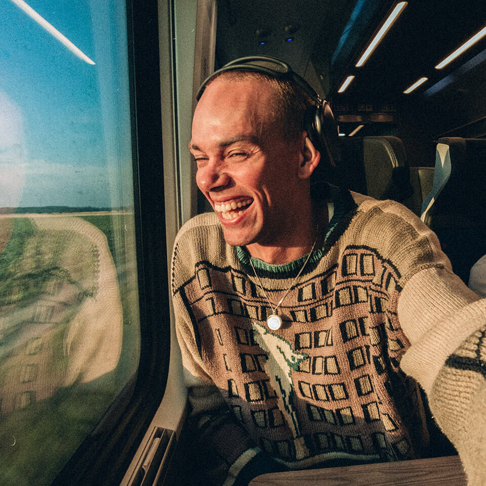 Someone laughs while sitting in a window seat
