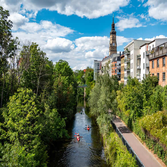 Los kayakistas navegan por un canal en Leipzig, bordeado de árboles
