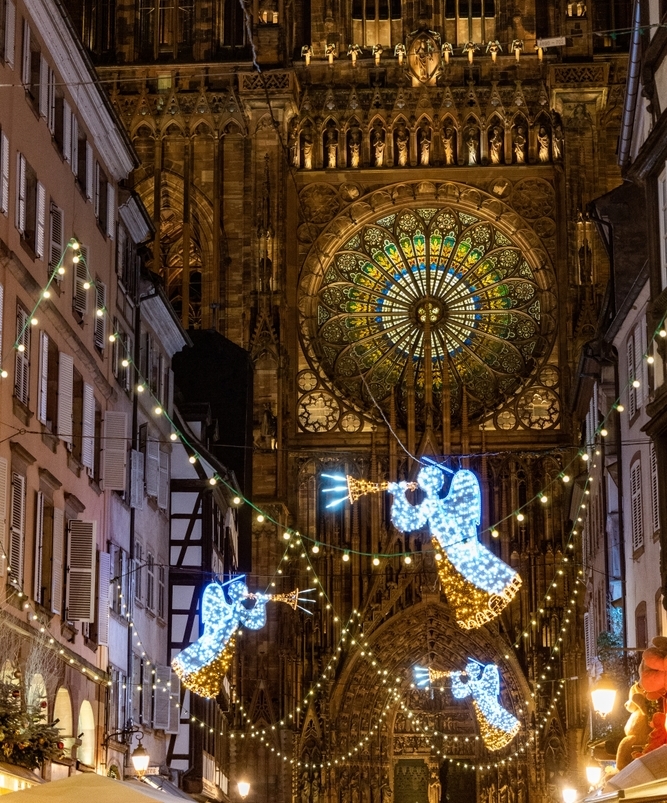 クリスマスイルミネーションに彩られた通りの先にそびえ立つ、ストラスブール大聖堂