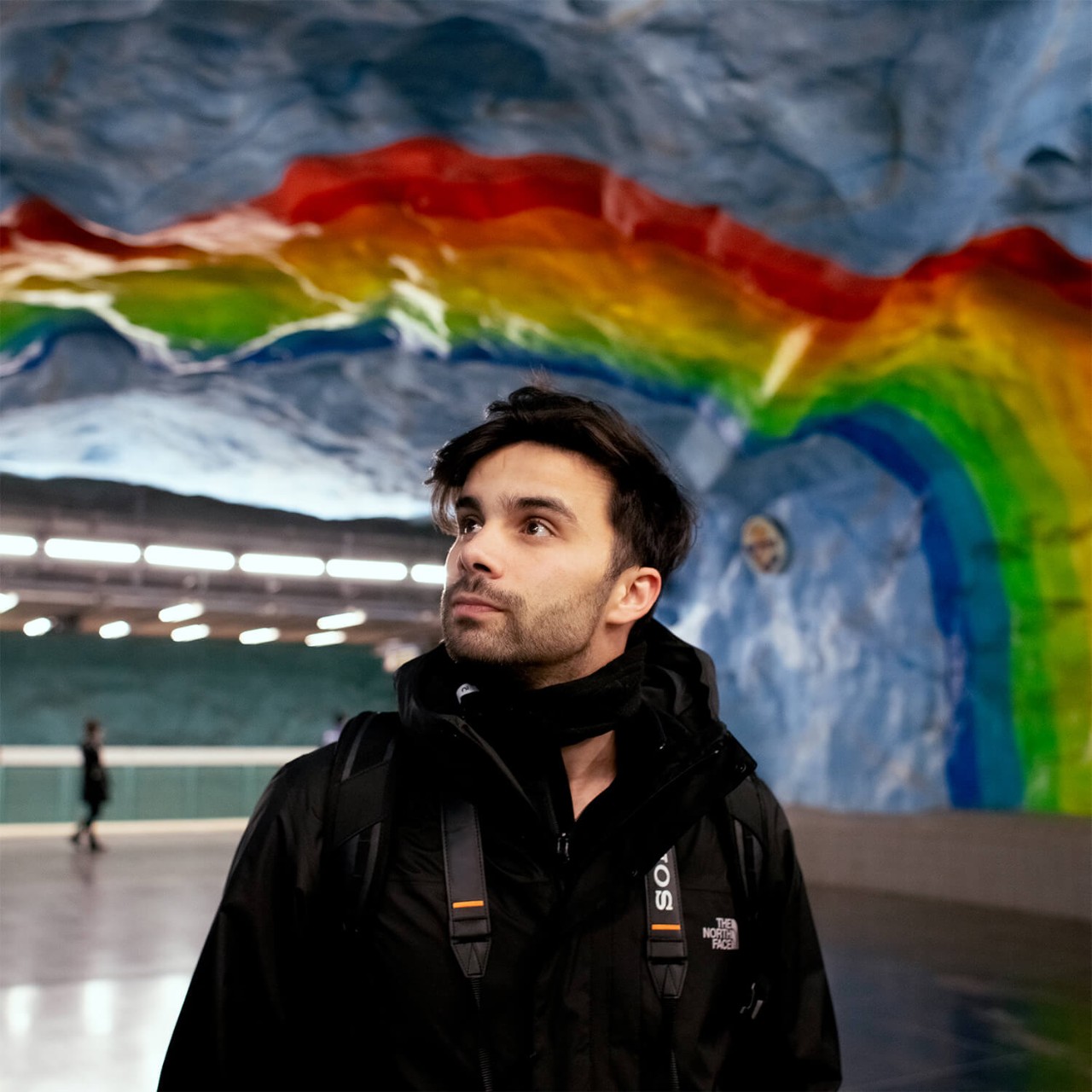 Een persoon bewondert de kleurrijke kunst in een metrostation in Stockholm